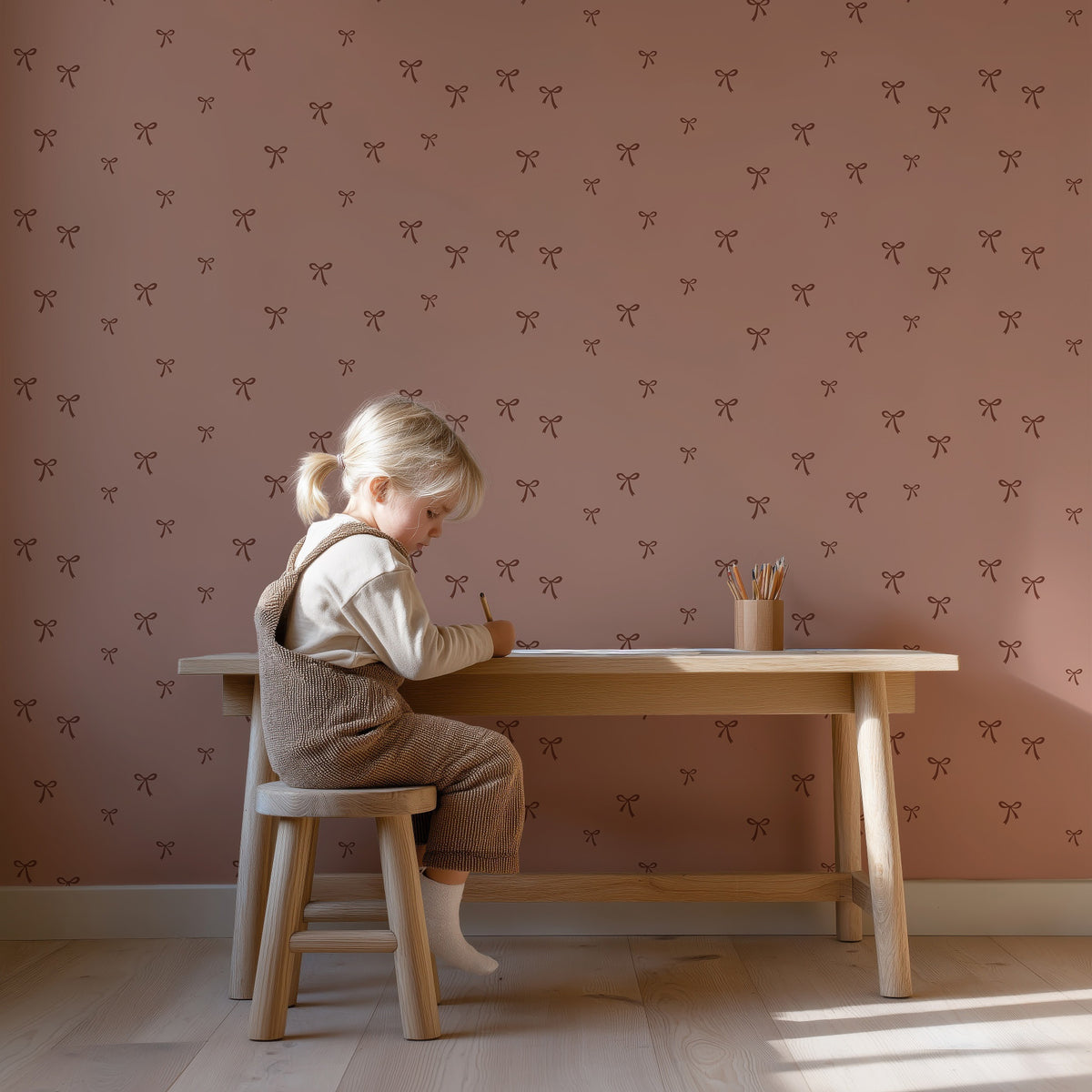 Strikjes - blush cacao behang als achtergrond bij een kind aan een houten bureau