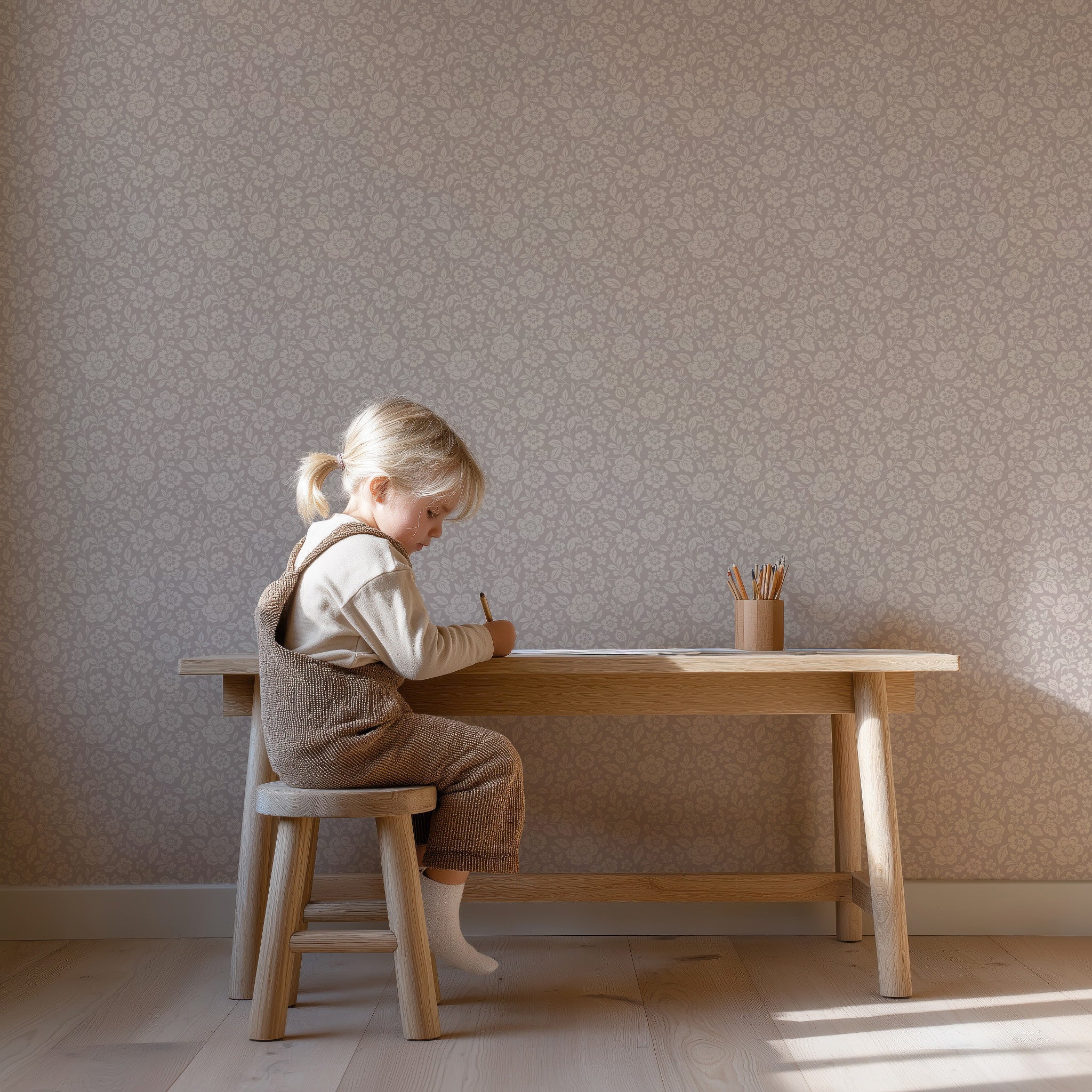 Meisje aan houten bureau in kinderkamer met Meadow Bloom heather bloemenbehang
