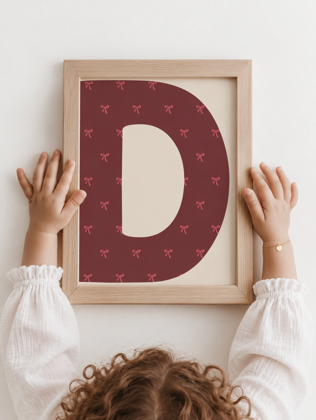 Gepersonaliseerde letterposter met strikjes in een meisjeskamer