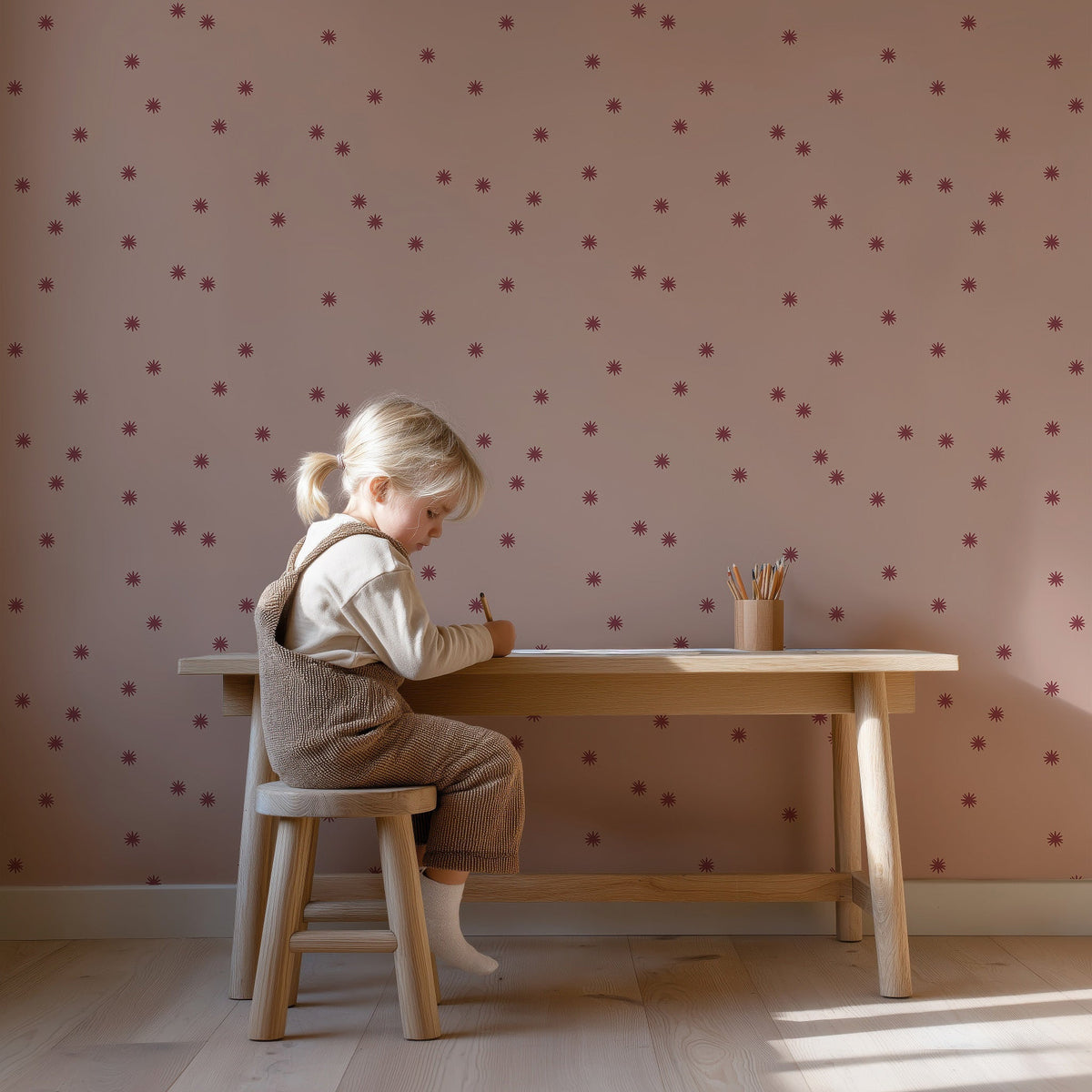 Meisje aan een houten bureau tegen Tiny Stars berry blush behang