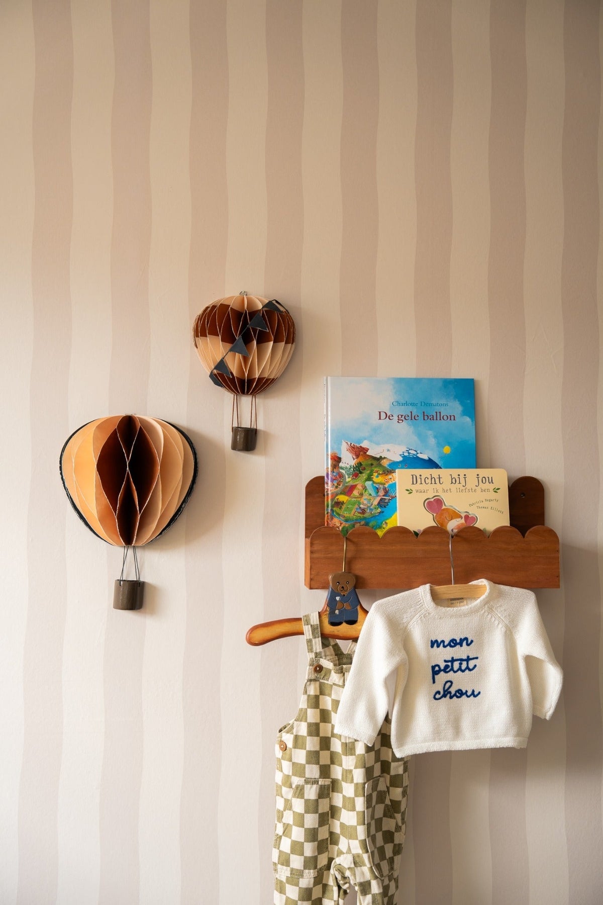 Babykamer van Judith met Wavy Stripes beige behang, luchtballonnen en babykleertjes