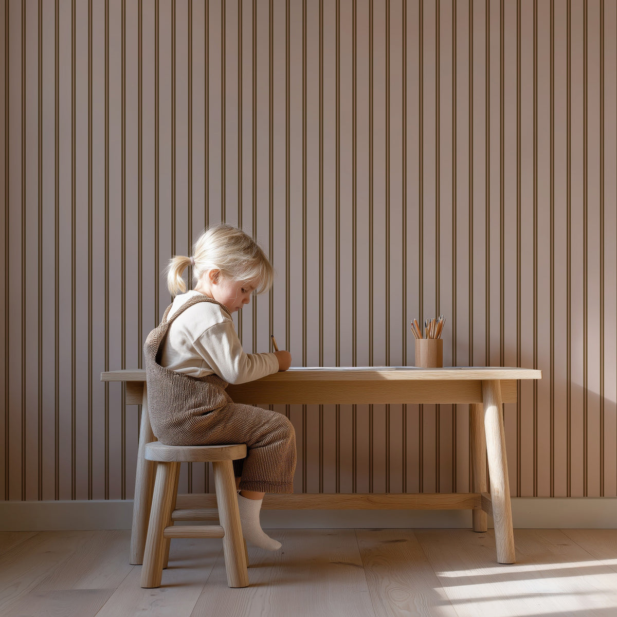 Twin Stripes - blush olive behang als achtergrond bij een kind aan een houten bureau