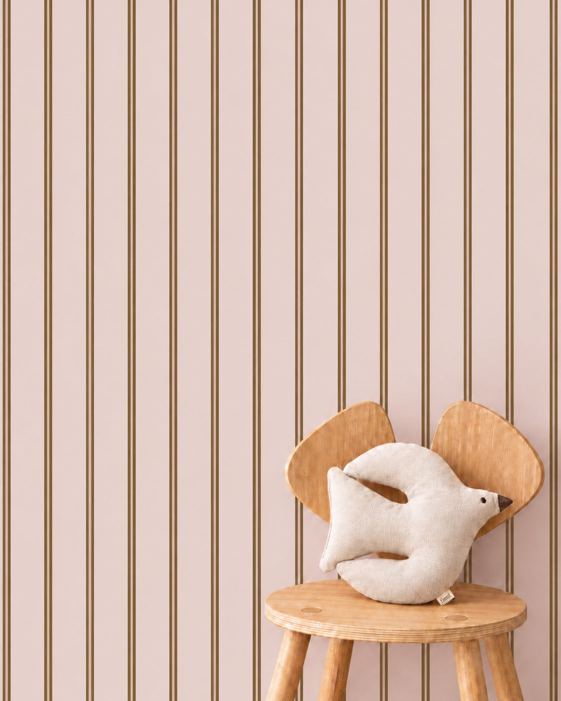 Twin Stripes - blush olive behang als achtergrond bij een houten stoel met een wit vogelkussen