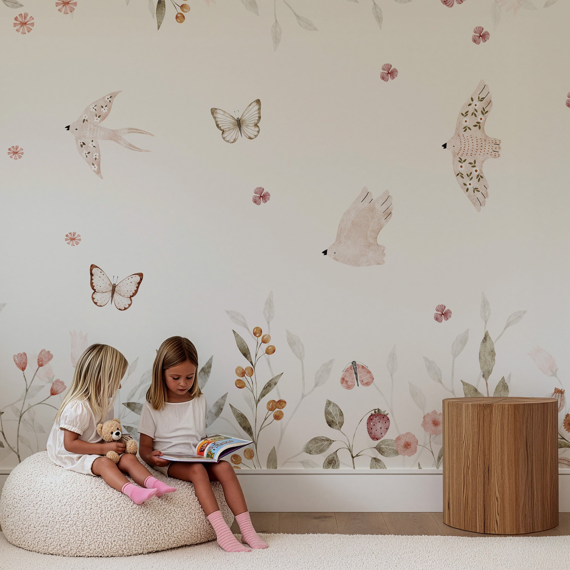 Collagebehang met zachte illustraties van bloemen, vogels en vlinders in een rustige kinderkamer.
